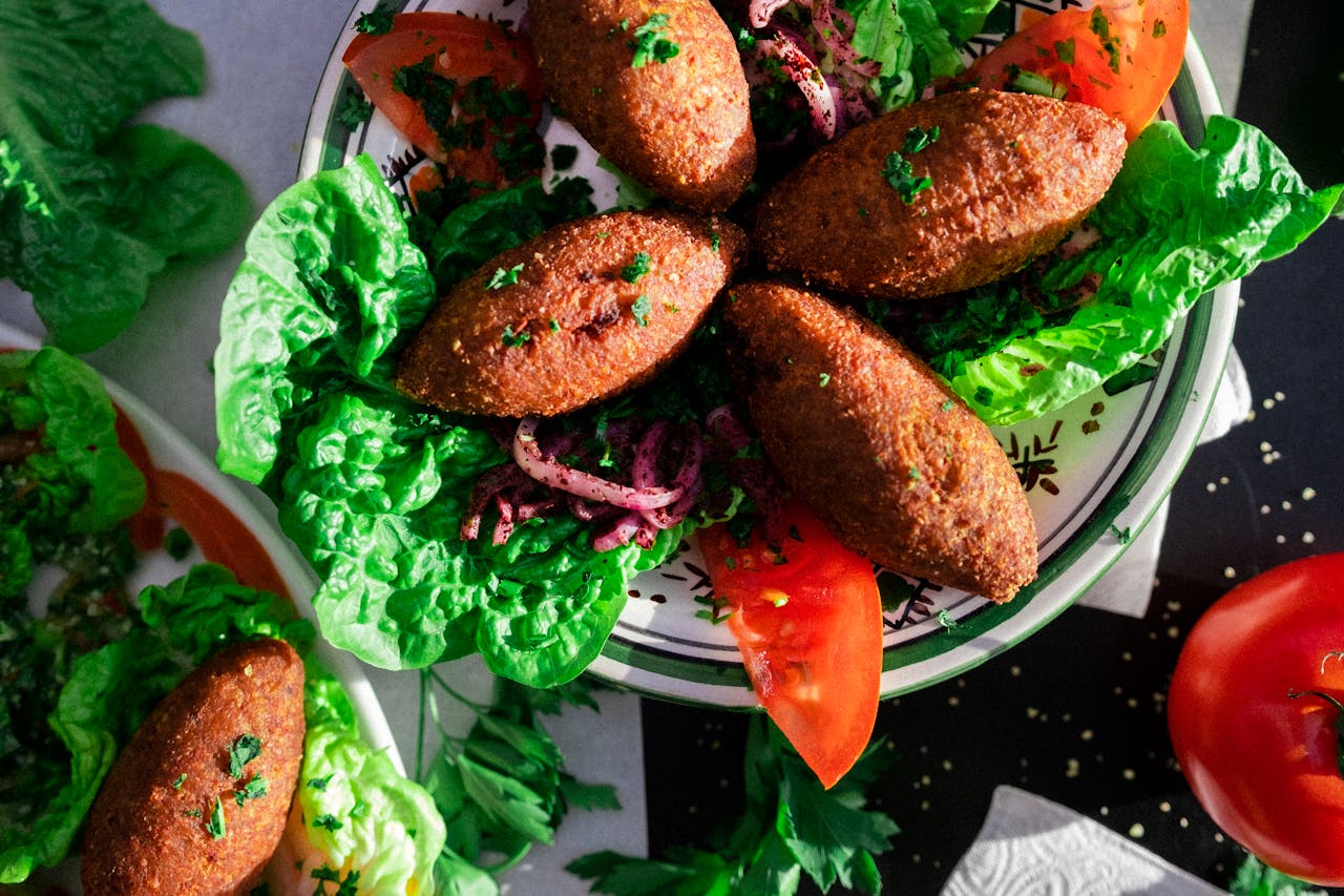 Delicious Lebanese kibbeh served on a bed of fresh greens and vegetables.